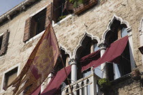 Italy, Veneto, Venice, Centro Storico, Flag of the Republic of Venice depicting winged lion flies from facade with islamic influenced window arches.