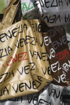 Italy, Veneto, Venice, Shopping bags on souvenir stall for sale opposite St Marks Square in the sunshine.