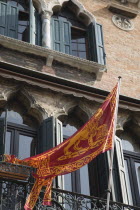 Italy, Veneto, Venice, Centro Storico, Republic of Venice flag depicting winged lion of St. Mark on facade of building with islamic influenced window arches.
