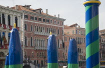 Italy, Veneto, Venice, Green, yellow and blue painted poles of gondola station from Rialto bridge looking along the Grand Canal.