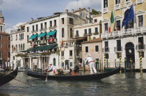 Italy, Veneto, Venice, Grand Canal, Participants in the Regata Storico historical Regatta held annually in September, wearing traditional costume, approaching the Rialto bridge with onlookers gathered...