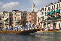 Italy, Veneto, Venice, Grand Canal, Participants in the Regata Storico historical Regatta held annually in September wearing traditional costume and approaching the Rialto bridge with onlookers gather...