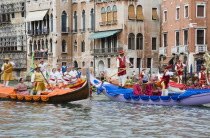 Italy, Veneto, Venice, Grand Canal, Participants in the Regata Storico historical regatta held annually in September wearing traditional costume approaching the Rialto bridge in brightly painted gondo...