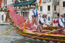 Italy, Veneto, Venice, Grand Canal, Participants in the Regatta Storico historical annual regatta wearing traditional costume rowing gondola past onlookers gathered on the balconies of canalside build...