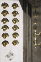 Italy, Veneto, Venice, Brass doorbells with nameplates on restored facade of apartment building entrance.