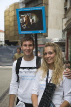 Hungary, Pest County, Budapest, attractive young student couple promoting mobile internet access near Saint Stephens Basilica.