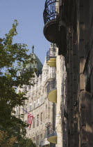 Hungary, Pest County, Budapest, renovated apartment buildings with US embassy and flag behind.