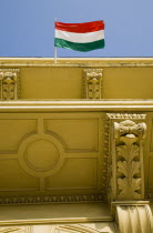 Hungary, Pest County, Budapest, Hungarian flag flying from partly seen rooftop of renovated building facade on Pest bank of the River Danube.