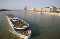 Hungary, Pest County, Budapest, pleasure cruise boat on the River Danube approaching Szechenyi Chain Bridge or Memory Bridge with Hungarian Parliament Building behind on right on Pest bank.