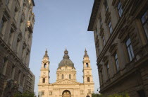 Hungary, Pest County, Budapest, view along street towards Saint Stephens Basilica exterior facade, twin bell towers and central dome.