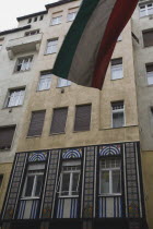 Hungary, Pest County, Budapest, Part view of Art Nouveau facade with flag in top foreground.