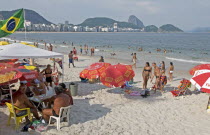 BRAZIL Rio de Janeiro Copacabana beach and Sugarloaf Mountain - beach umbrellas swimers in sea bikinis and Brazilian flag