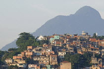 BRAZIL Rio de Janeiro Favela or slum above Saude neighbourhood, brick houses trees Church and mountain in the background.