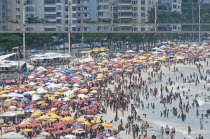 BRAZIL Rio de Janeiro Copacabana beach, crowds on the beach and in the sea multi-coloured beach umbrellas.