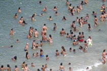 BRAZIL Rio de Janeiro Copacabana beach, multiracial singles children and family groups in the sea, bikinis.