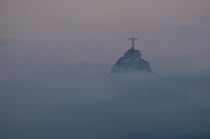 BRAZIL Rio de Janeiro The statue of Christ the Redeemer and the peak of Corcovado mountain above the cloud as dawn breaks over the city