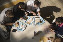 Hungary, Pest County, Budapest, looking down on customers having lunchtime meal of Hungarian sausage, bread, beans and salad seated at circular table in Nagy Vasarcsarnok, the Central Market.