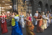 Hungary, Pest County, Budapest, Hare Krishna devotees singing and dancing on Andrassy UtIn Pest with graffiti covered doorway behind. The International Society for Krishna Consciousness or ISKCON, als...