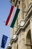 Hungary, Pest County, Budapest, Hungarian and EU flags fying from facade of building on the River Danube in Pest.