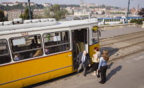 Hungary, Pest County, Budapest, tram with passengers alighting and view towards the River Danube behind.