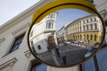 Hungary, Pest County, Budapest, circular traffic guiding mirror reflecting apartments on River Danube bank in Pest.