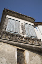 Greece, Northern Aegean, Samos Island, Vathy, detail of old house with wooden window shutters and exposed timber frame, view from below looking upwards.