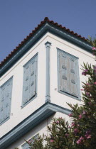Greece, Northern Aegean, Samos Island, Vathy, part view of house facade with tiled roof and blue painted wooden window shutters.
