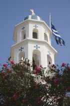 Greece, Northern Aegean, Samos Island, Vathy, White and turquoise Greek Orthodox Church bell tower with domed roof and with Greek flag flying at side.