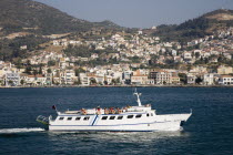 Greece, Northern Aegean, Samos, Vathy, ferry between Samos and Kusadasi in Turkey as it leaves Vathy with town houses spread out across hillside beyond.