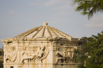 Greece, Attica, Athens, Tower of the Winds on the Roman Agora in Athens. Part view of octagonal Pentelic marble clocktower with frieze depicting the wind gods.