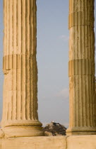 Greece, Athens, Part view of Acropolis and Parthenon columns framing distant view towards Lycabetus Hill.