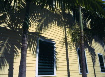 USA, Florida, Key West, Detail of calpperboard building with palm trees and shadows.