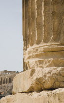 Greece, Athens, Base of ruined column on The Temple of Olympian Zeus with Parthenon and Acropolis behind. 