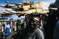 Tanzania, West, Great Lakes Region, Refugee woman carrying bundle of firewood on her head. 