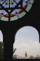 Turkey, Istanbul, Sultanahmet, Part view of dirty stained glass window in Ottoman era waiting room framing view to Galata Tower on Golden Horn.