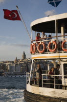 Turkey, Istanbul, Sultanahmet, Passenger ferry flying Turkish flag on the Bosphorous with city behind. Since March 2006, Istanbuls traditional commuter ferries have been operated by Istanbul Sea Buses...