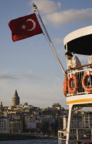 Turkey, Istanbul, Sultanahmet, Part view of passenger ferry flying Turkish flag with man leaning on railings of upper deck. Since March 2006, Istanbuls traditional commuter ferries have been operated...