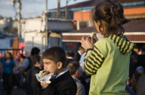 Turkey, Istanbul, Sultanahmet, Turkish boy and girl eating grilled fresh fish in bread at Kumkapi between Bosphorous and Galata Bridge.