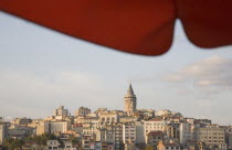 Turkey, Istanbul, Sultanahmet, View to Galata Tower from shade of red canopy alongside Galata bridge.