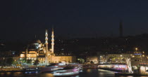 Turkey, Istanbul, Sultanahmet, The Golden Horn. The New Mosque or Yeni Camii at left, the Galata Bridge, and Suleymaniye Mosque at right illuminated at night with boats on the Bosphorus in motion blur...
