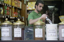 Turkey, Istanbul, Sultanahmet. Coffee or kahve shop and young, male vendor in the The Spice Bazaar or Egyptian Bazaar, one of the oldest bazaars in the city and the second largest covered shopping com...
