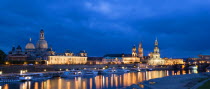 GERMANY, Saxony, Dresden, The city skyline at night with cruise boats moored on the River Elbe in front of the illuminated embankment buildings on the Bruhl Terrace of the Art Academy the Frauenkirche...