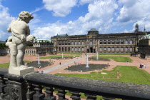 GERMANY, Saxony, Dresden, The central Courtyard and Picture Gallery of the restored Baroque Zwinger Palace gardens busy with tourists seen from the statue lined Rampart originally built between 1710 a...