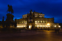 GERMANY, Saxony, Dresden, The restored Baroque Sachsische Staatsoper or State Opera House in Theatre Square first built in 1841 by architect Gottfried Semper illuminated at sunset with an equestrian s...