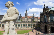 GERMANY, Saxony, Dresden, The central Courtyard of the restored Baroque Zwinger Palace gardens busy with tourists seen from the statue lined Rampart originally built between 1710 and 1732 after a desi...