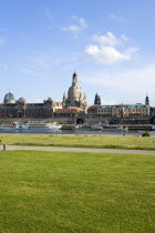 GERMANY, Saxony, Dresden, The city skyline with cruise boats moored on the River Elbe in front of the embankment buildings on the Bruhl Terrace busy with tourists of the Art Academy the Frauenkirche C...