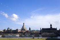 GERMANY, Saxony, Dresden, The city skyline with cruise boats moored on the River Elbe in front of the embankment buildings on the Bruhl Terrace busy with tourists of the Art Academy the Frauenkirche C...