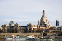 GERMANY, Saxony, Dresden, The city skyline with cruise boats moored on the River Elbe in front of the embankment buildings on the Bruhl Terrace busy with tourists of the Art Academy and the Frauenkirc...