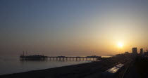 England, East Sussex, Brighton, View of the pier at sunset from the seafront promenade in Kemptown.