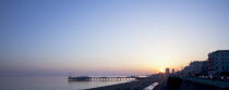 England, East Sussex, Brighton, View of the pier at sunset from the seafront promenade in Kemptown.